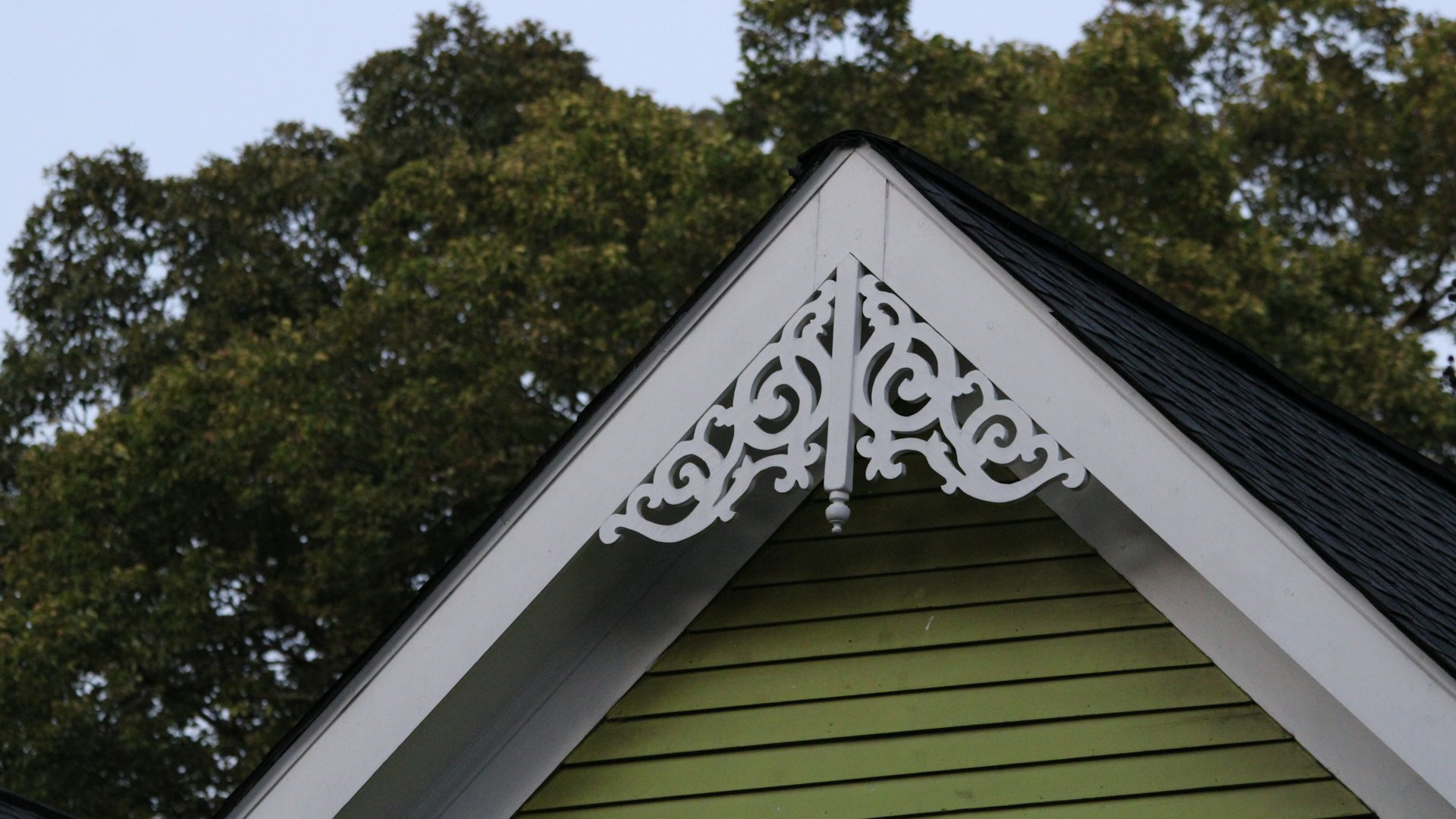 White fascia and gable trim on a green clapboard house