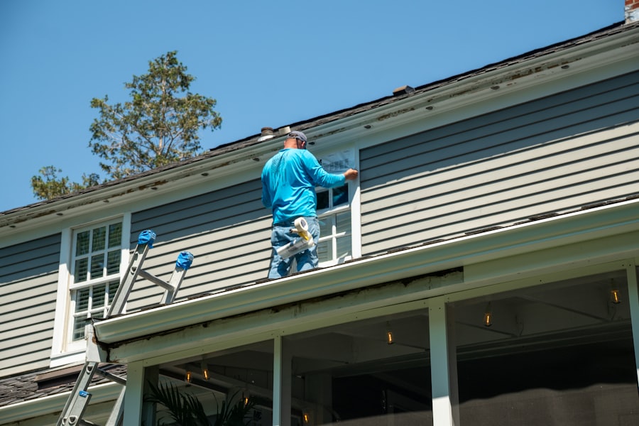 Working on a window from a ladder outside a house